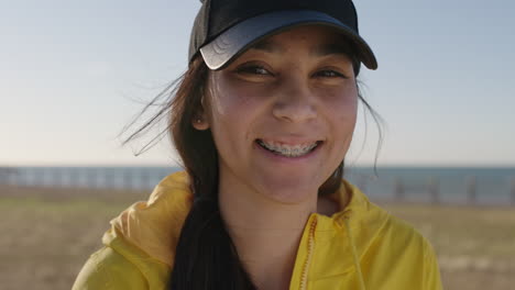 close up portrait of awkward teenage girl smiling cheerful looking at camera wearing braces enjoying sunny seaside park