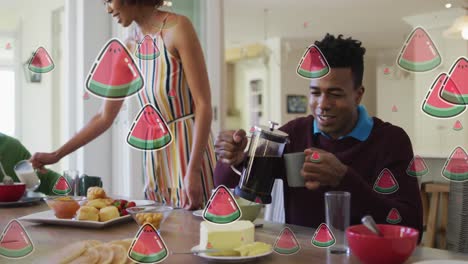 Animation-of-watermelon-slices-over-diverse-couple-having-breakfast-at-home