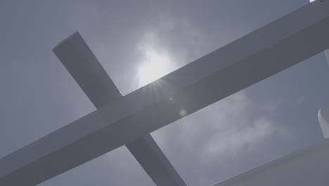 prise de vue à bas angle d'un cadre de plafond en bois devant un ciel bleu avec le soleil créant des fusées solaires