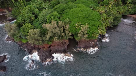Big-Island-Hawaii---Drone-descent,-looking-into-a-cove-with-cave