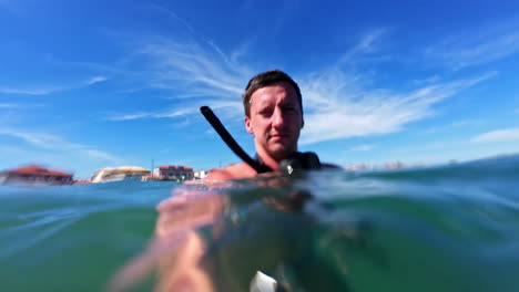 caucasian male in water preparing to dive underwater