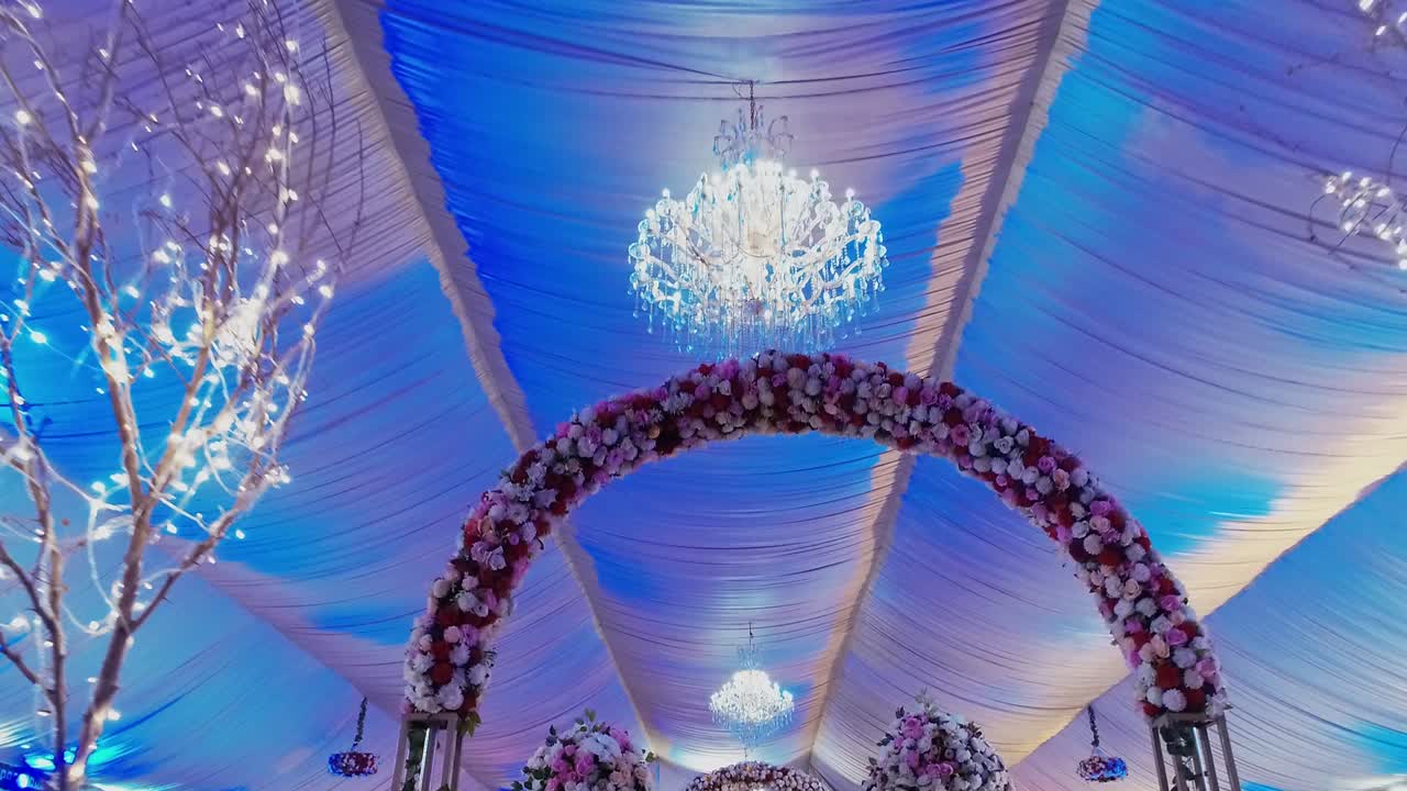 en este increíble lugar de bodas, el techo cuenta con una encantadora lámpara de lámparas y decoraciones florales