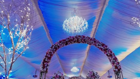 in this amazing wedding venue, the ceiling features a lovely chandelier and flower decorations