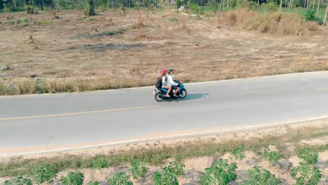 chico con gorra azul chica con pañuelo rojo montando en moto azul