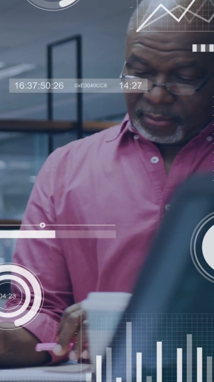 Vertical video: Man noting docs at desk while HUD charts overlaying docs, aiding business choices