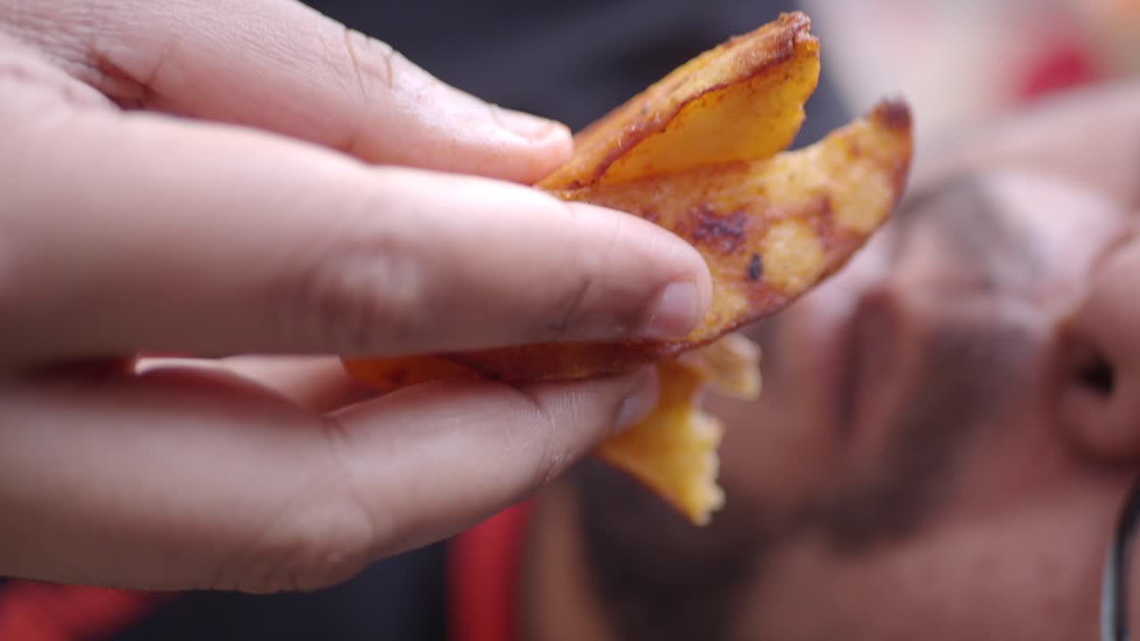 Person eating a fried potato chip