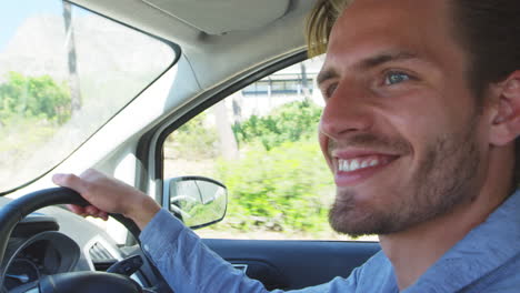 un joven sonriente conduciendo un coche en un viaje por carretera