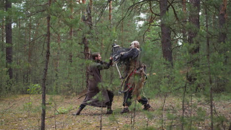 Hombre-Armado-Lucha-Contra-El-Aterrador-Ataque-De-Una-Bestia-En-Un-Bosque-De-Pinos