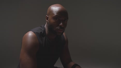 retrato de estudio de un atleta masculino con chaleco deportivo contra un fondo negro 1