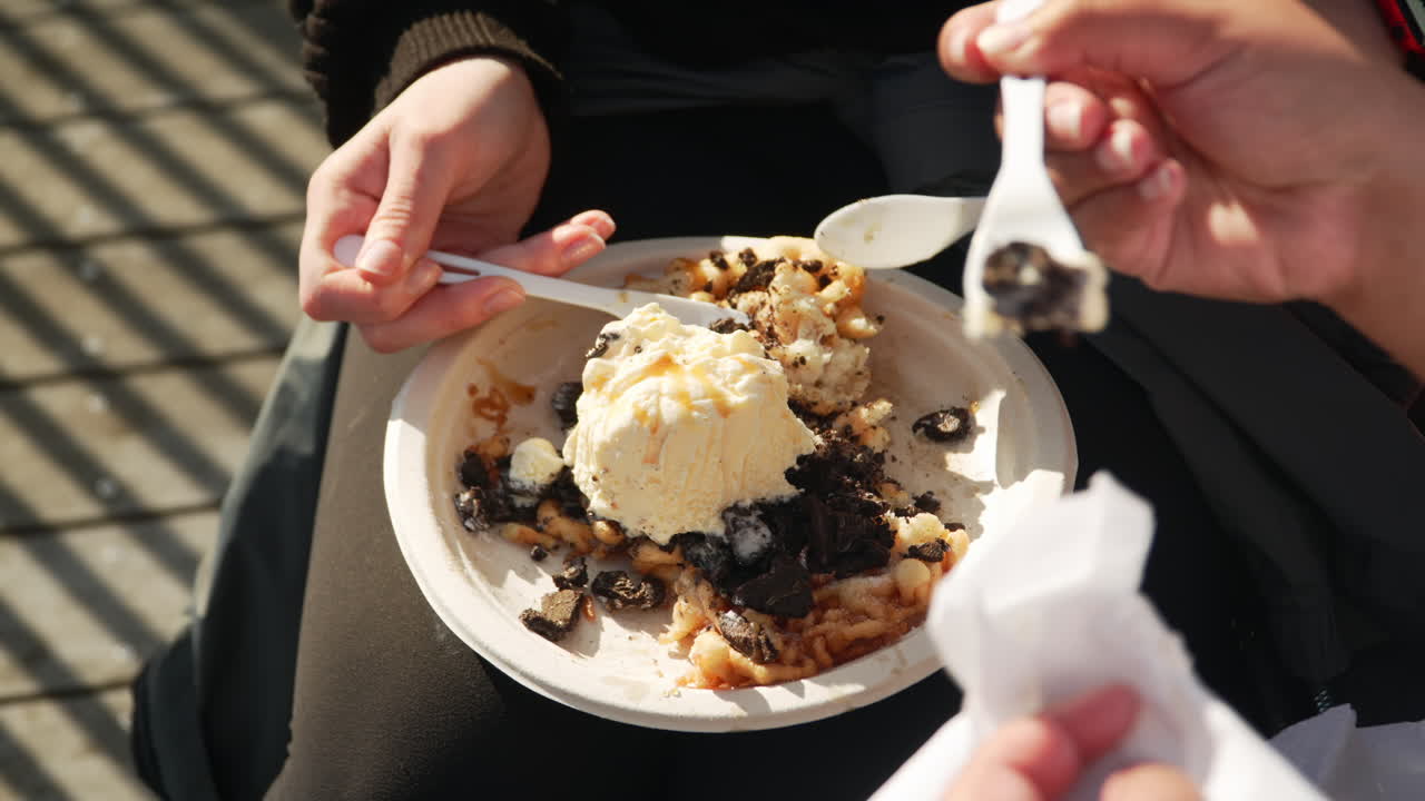 Enjoying funnel cake topped with ice cream at a carnival