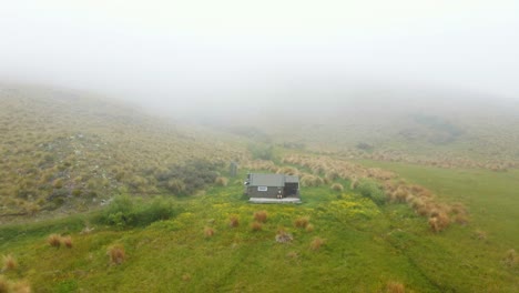 Luftaufnahme-Einer-Abgelegenen-Wanderhütte-Mit-Tiefem,-Dichtem-Nebel