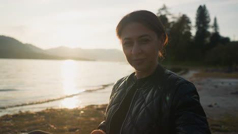 la dama ofrece croissant al hombre al atardecer. la pareja disfruta de un picnic con el ambiente romántico del atardecer en la orilla del río juntos. concepto de relación feliz