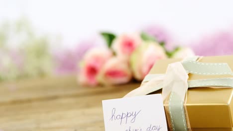 gift box with happy mother day card on wooden surface