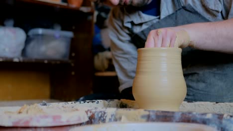 2 shots. professional male potter making pot in pottery workshop