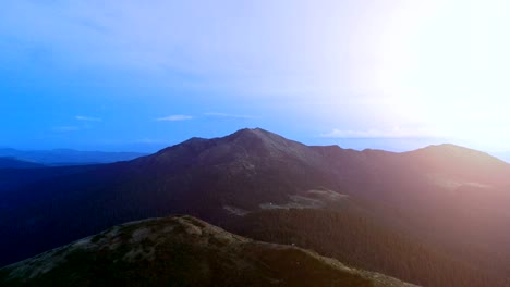 the flight above picturesque mountains on the sunset background