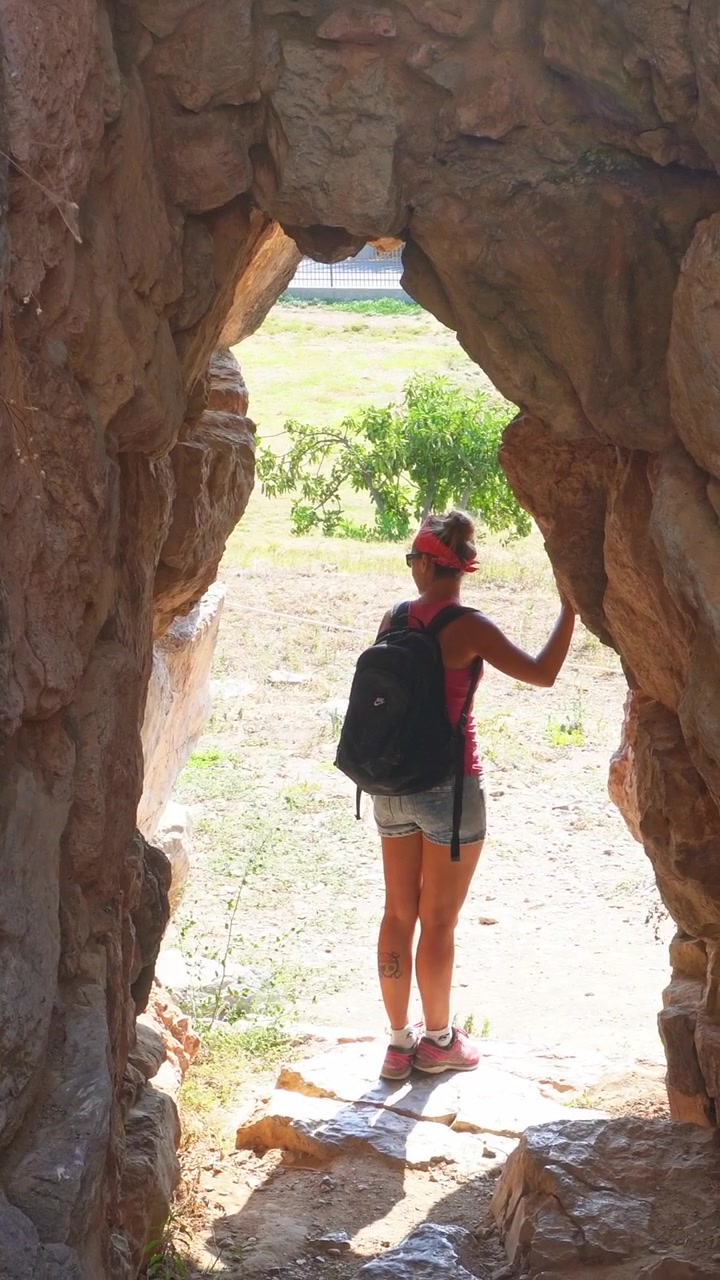 Woman exploring ancient stone ruins in Tiryns, Greece