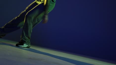 male legs, hip-hop dancer dancing isolated over dark blue background in neon light. modern dance art, fashion, youth, ad, style. 4k, video