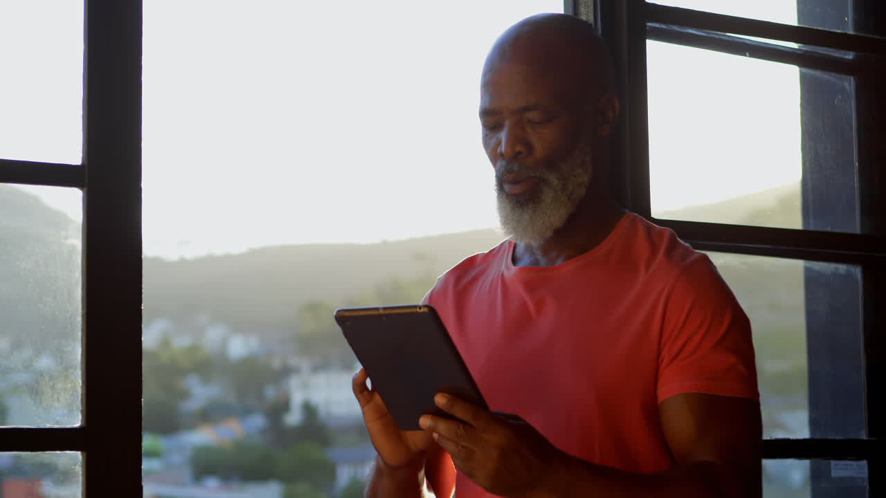 Senior man using digital tablet at home 4k