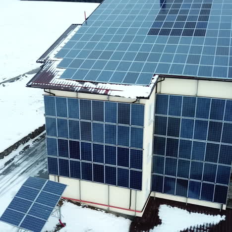 hotel complex in the mountains with solar panels on the snow. rows of snow covered solar panels in a small solar power plant.