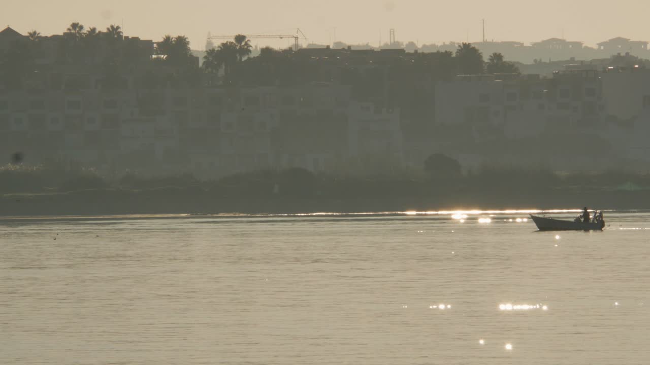barco de pesca cruzando el río en una mañana soleada reflejos de la luz del sol, portimão - algarve