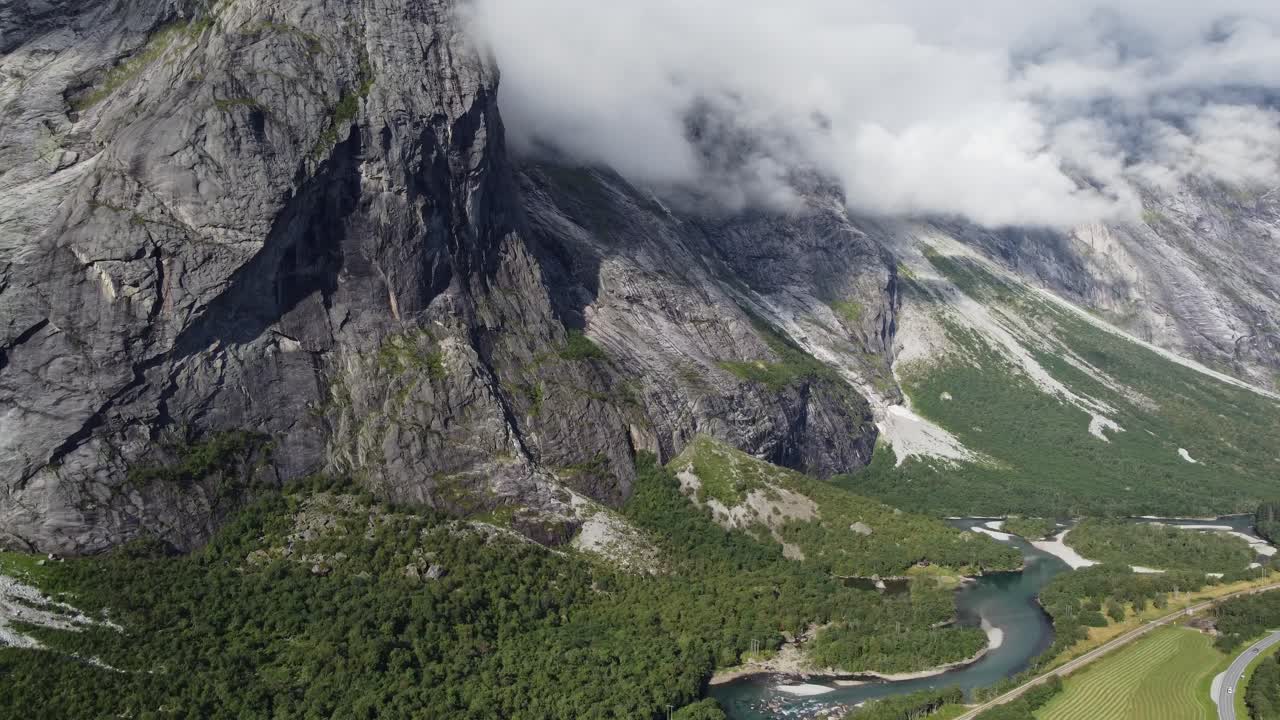 Riprese aeree che mostrano il fiume Rauma in Norvegia, con montagne, vegetazione e erba.
