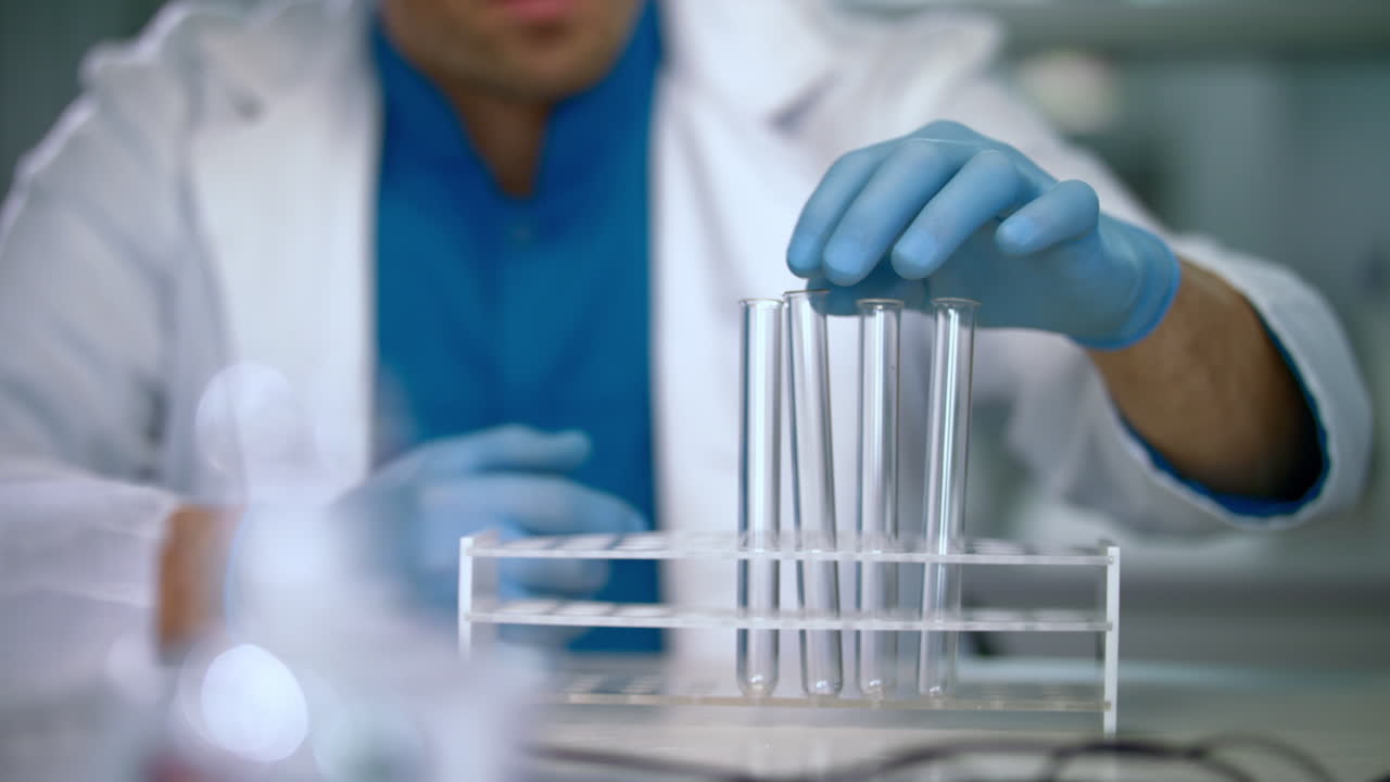 tubos de ensayo vacíos en el estante. trabajador de laboratorio preparando cristalería de laboratorio