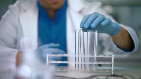 tubos de ensayo vacíos en el estante. trabajador de laboratorio preparando cristalería de laboratorio