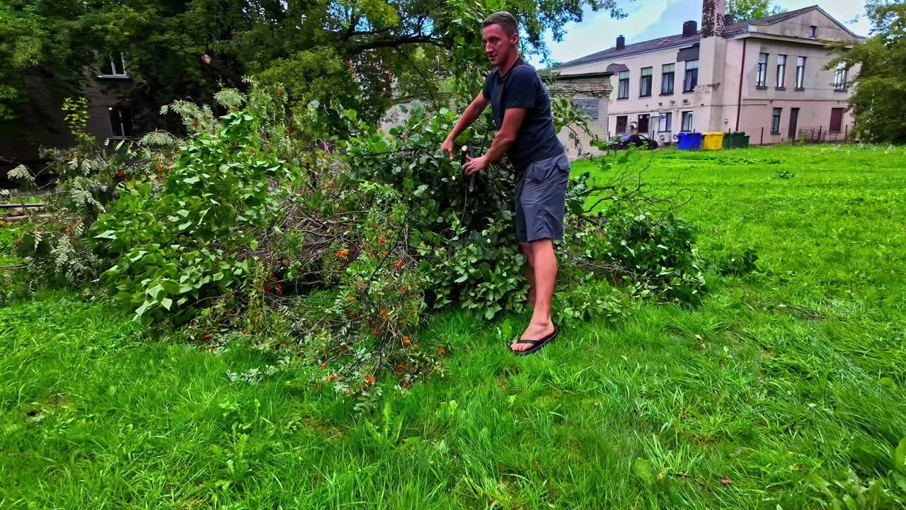 A man collects bush debris after a storm