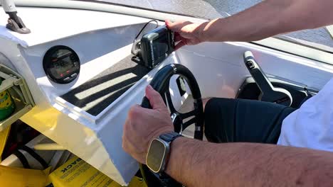 hands steering a boat on calm waters