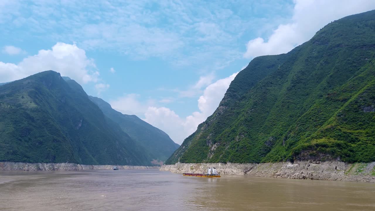 Cargo ship transporting goods, products and vehicles sailing through the gorge on the magnificent Yangtze River, China