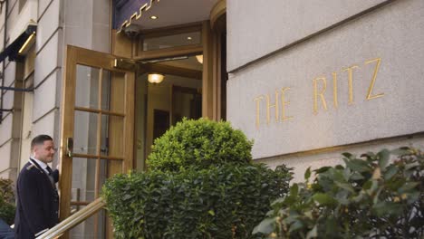 Close-Up-Of-Sign-Outside-The-Ritz-Hotel-And-Doorman-On-Piccadilly-In-London-UK