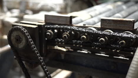 Closeup-of-rotating-gears-and-chains-on-industry-machine-conveyor-roller