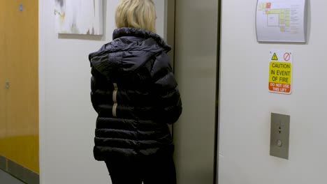 una chica rubia atractiva entra en un ascensor