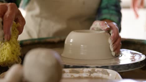 mid-section of female potter making pot