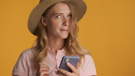 Caucasian-woman-in-a-hat-texting-on-smartphone.