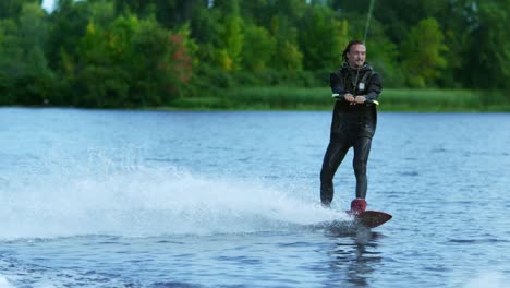 young man riding wakeboard on summer lake. man enjoying extreme holidays