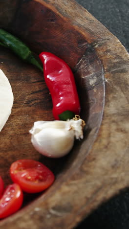 pizza dough with vegetables and spices on wooden tray