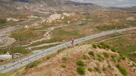 American-flag-on-top-of-a-hill-near-highway-15-near-Phelan,-California