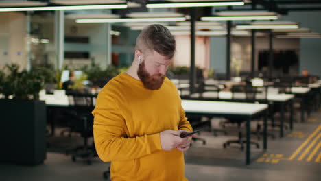 hombre usando un teléfono inteligente en una oficina moderna