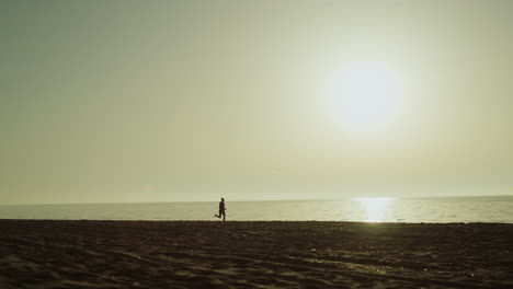 unknown sportswoman running seaside. silhouette jogging woman on sunset.