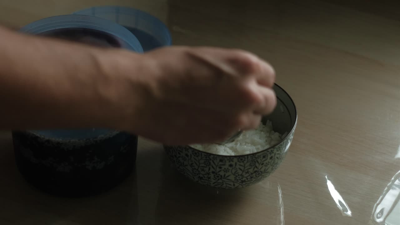 Persons Hand Getting Soy Marinated Eggs Onto The Bowl Of Rice. - closeup shot