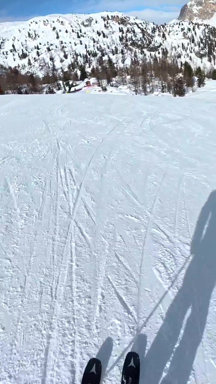 First-Person View of Skier Descending a Snowy Mountain Slope