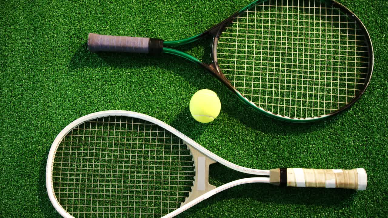 Pallina da tennis e racchette disposte sull'erba 4K