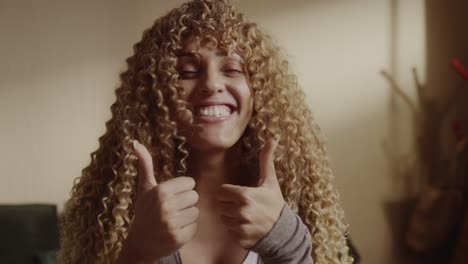 a happy woman with curly hair gives a double thumbs up