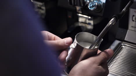 barista steaming milk with espresso machine for latte or cappuccino