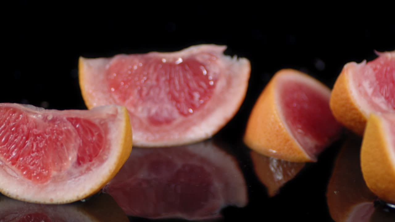 신선한 그레이프프루트 조각이 물에 어져 떨어집니다.