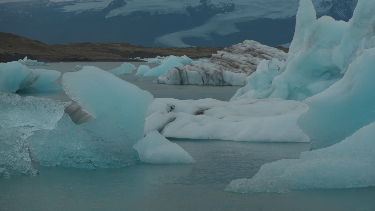 glaciares flotando en la laguna de glaciares, islandia, con gaviotas volando por encima, contra el telón de fondo de aguas azules moviéndose hacia la playa de diamantes
