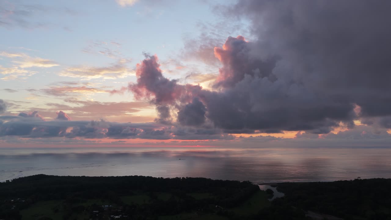 Aerial View of a Dramatic Sunset Over the Ocean and Tropical Coastline