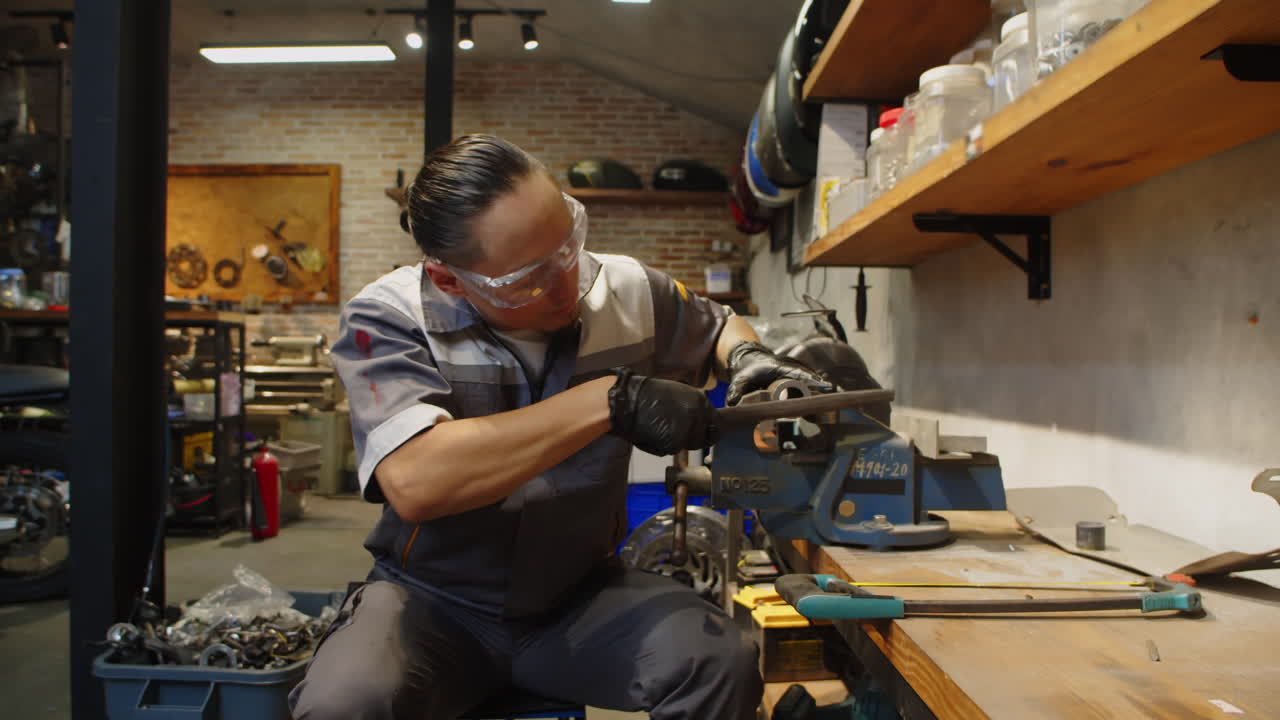 Mechanic in Uniform and Googles Grinding Instrument