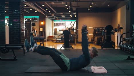 caucasian man doing v-ups abs and obliques workout in modern gym